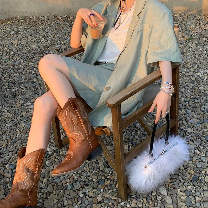 Brown women's mid-calf boots with embroidery detail, round toe, and low square heel.