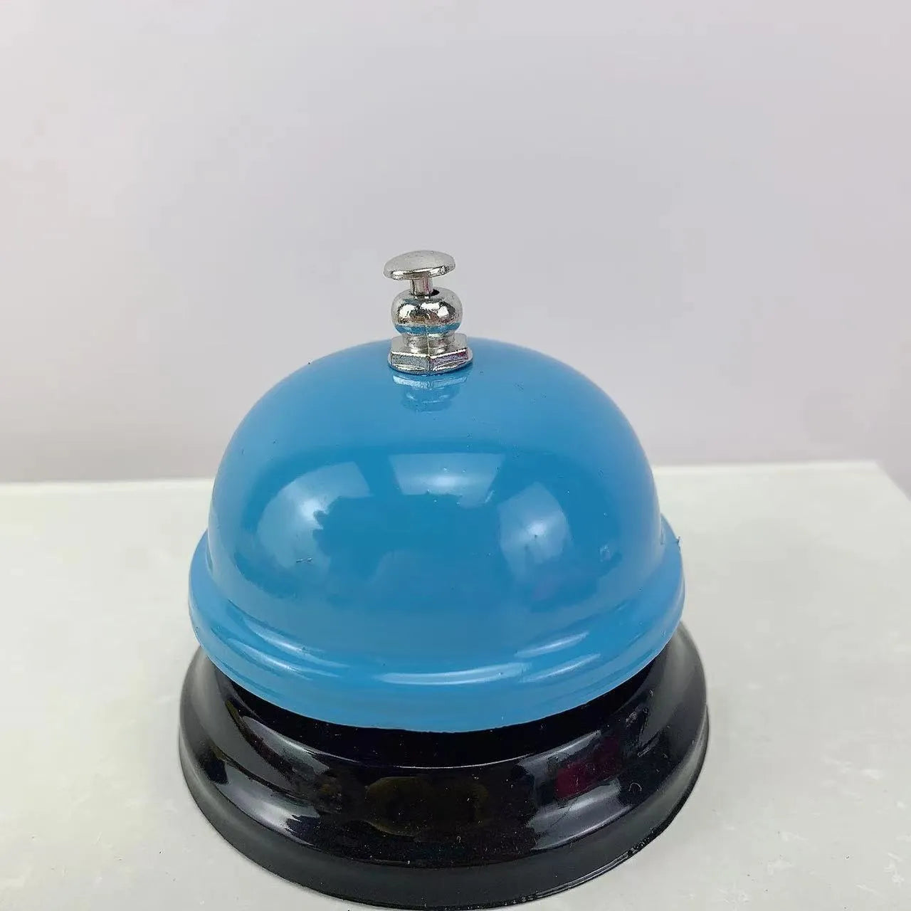 Handheld iron game bell in one of ten colours like red, blue, or green tea, for classroom or restaurant use.