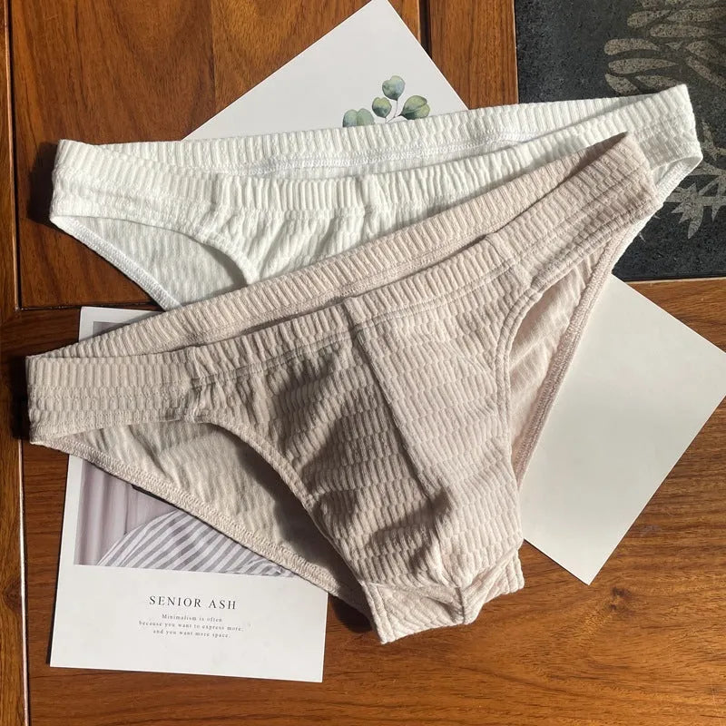 Men's pure cotton triangle underwear briefs in solid colours like black, white, and apricot on a mid-waist fit model.