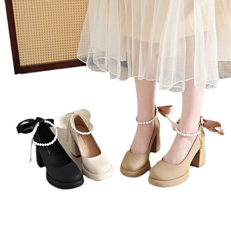 Women's beige Mary Jane shoes with a chunky heel and an ankle-strap buckle on a round toe.