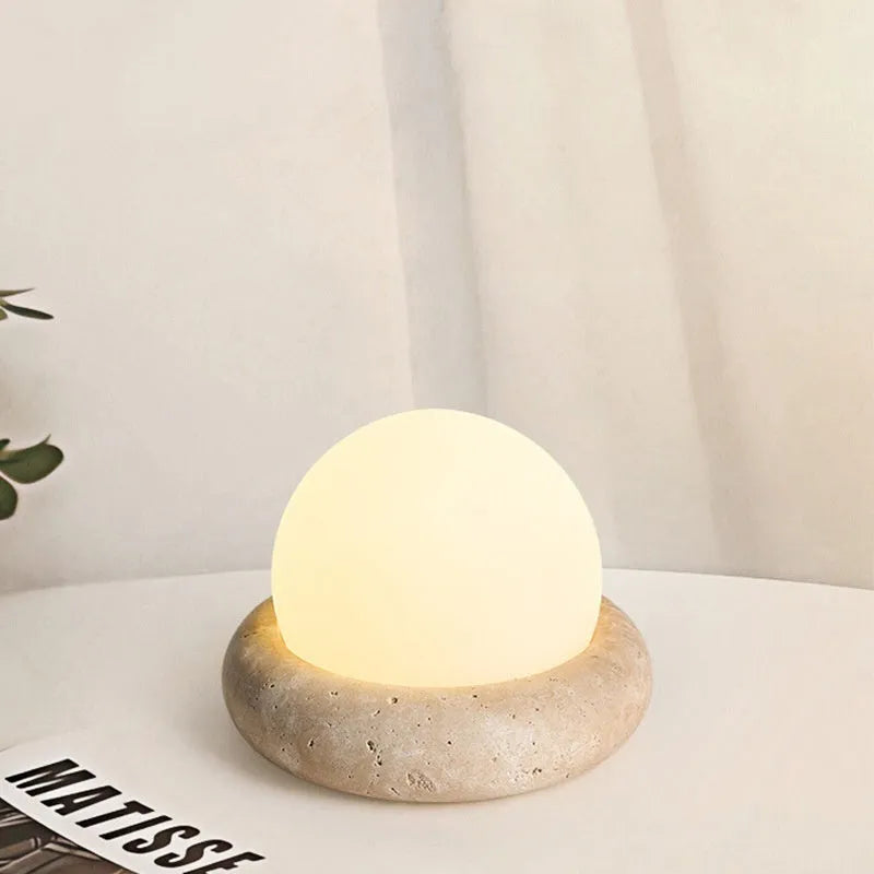 Cream-coloured modern bedside night lamp with remote control on wooden table