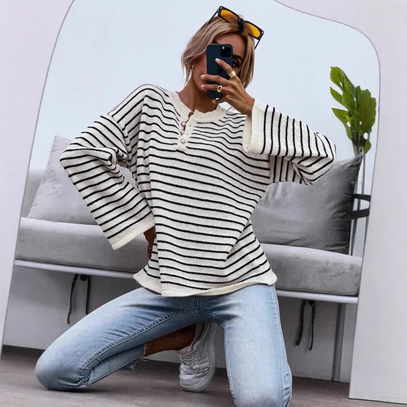 Black striped women's loose long-sleeve top with drop shoulders on a hanger.