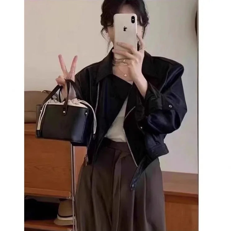 Women's slim-fit short brown retro leather jacket with long sleeves and a pocket.