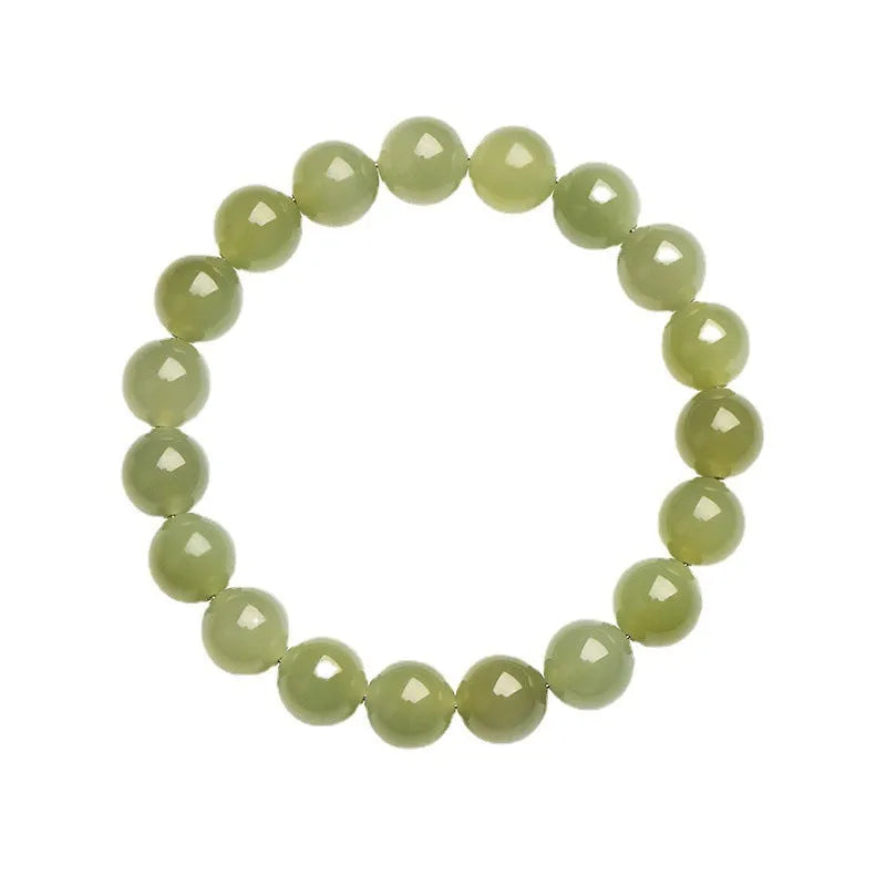 A close-up of a Hetian jade ball bracelet showing polished spherical beads in a clear stone colour, laid flat.