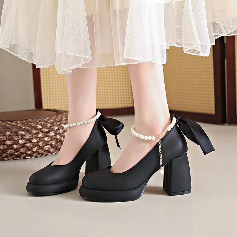 Women's beige Mary Jane shoes with a chunky heel and an ankle-strap buckle on a round toe.