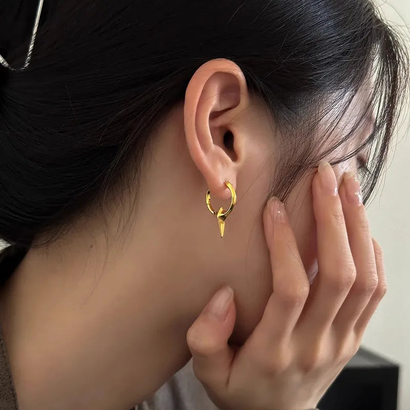 A pair of platinum-coloured geometric star-shaped ear clips for women on a white background.