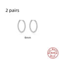 A pair of twisted sterling silver round earrings in a geometric design on a white background.