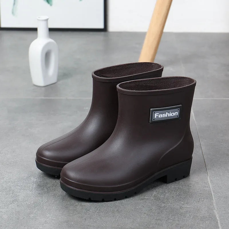 Women's mid-calf PVC rain boot in black with a low heel on a white background.