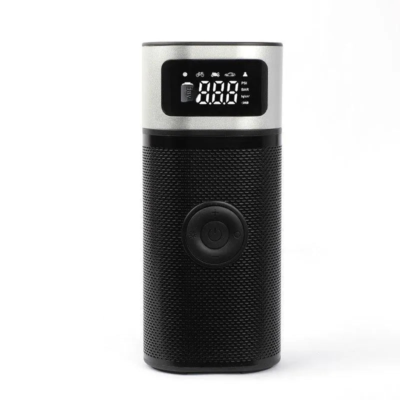 Black portable wireless smart air pump with display, charging cable and nozzle attachments on a dark surface.