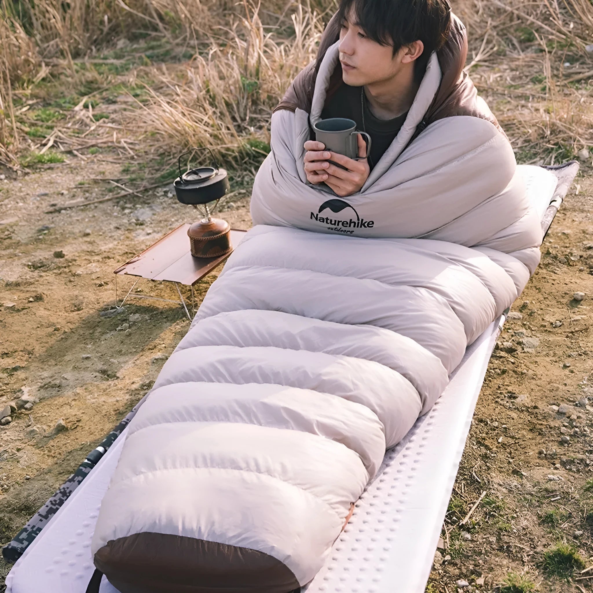 Goose down mummy sleeping bag shown with storage bag for camping and outdoor use