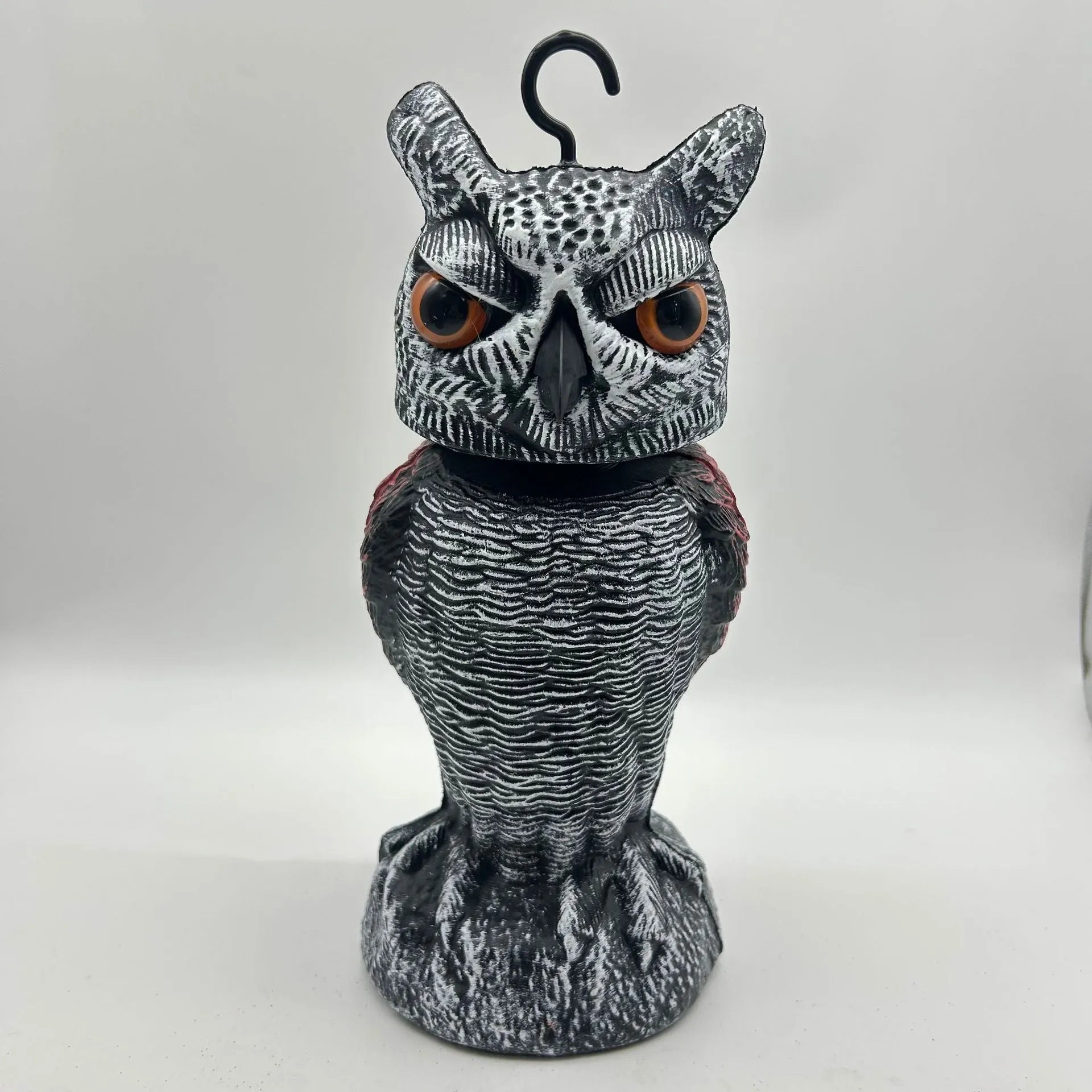 Artificial owl bait ornament with shaking head for garden bird deterrent in outdoor setting