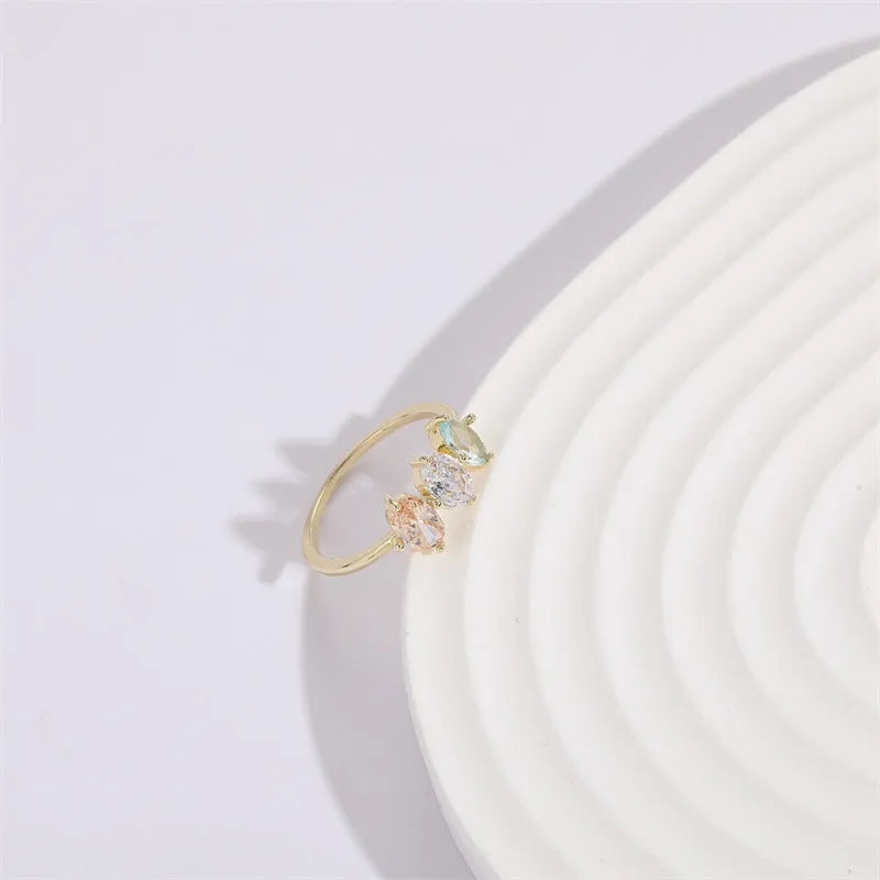 Gold geometric women's ring with horse eye design and three coloured zircon stones on a triangular band.