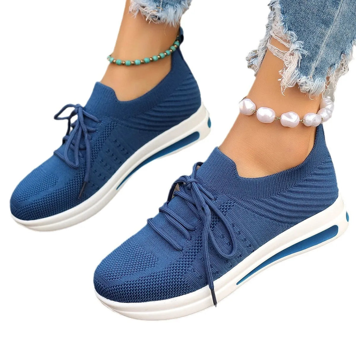 Women's low-top fly-knit sneakers in red, with a round toe and front lace-up closure on an injection-moulded sole.