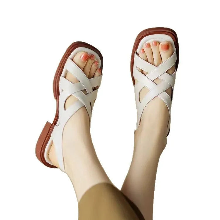 Women's glossy patent leather low heel sandals with square toe and cross-strap in black, brown and white.