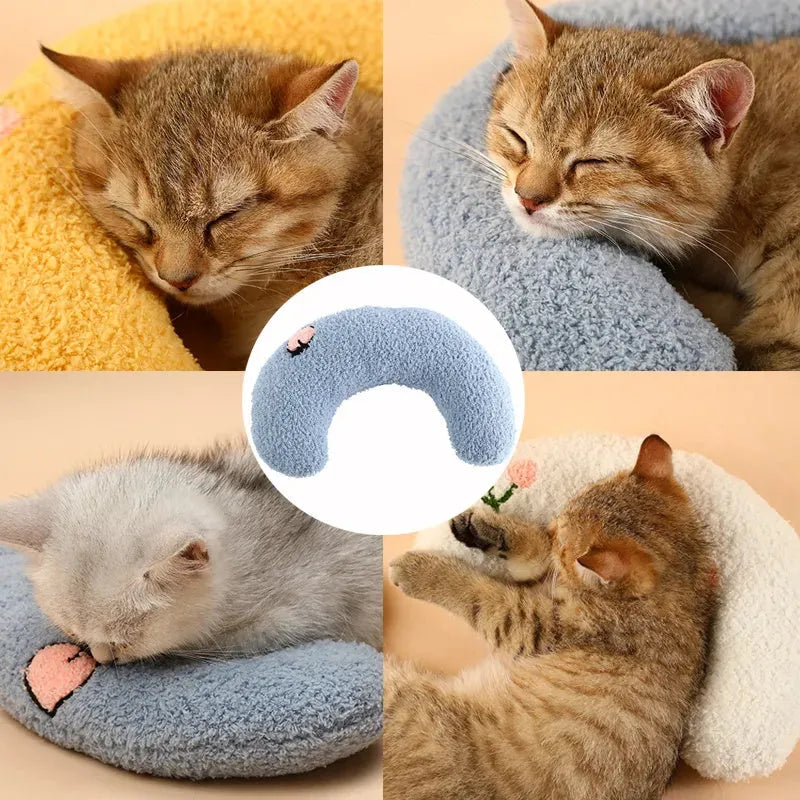 Small white U-shaped plush pet pillow for cats and small dogs on a neutral background.