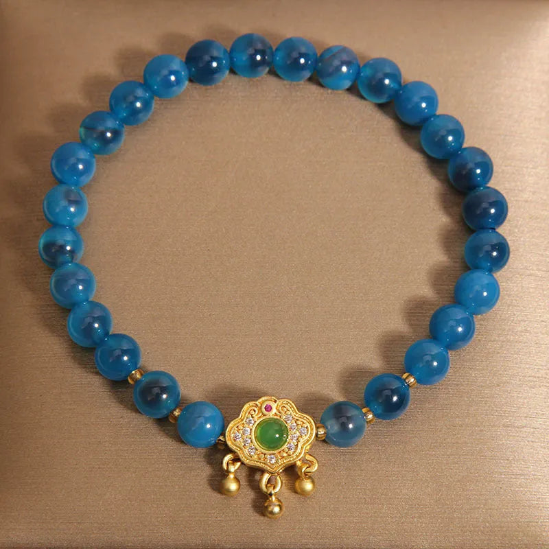 Blue sugar heart agate safety lock pendant on a crystal women's bracelet with rhinestone details.