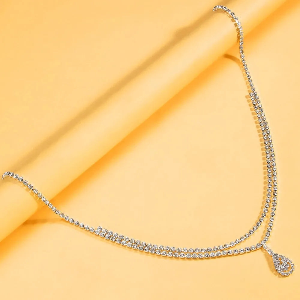Gold or silver waist chain with water drop pendant and tassel elements, 115cm length with lobster clasp closure