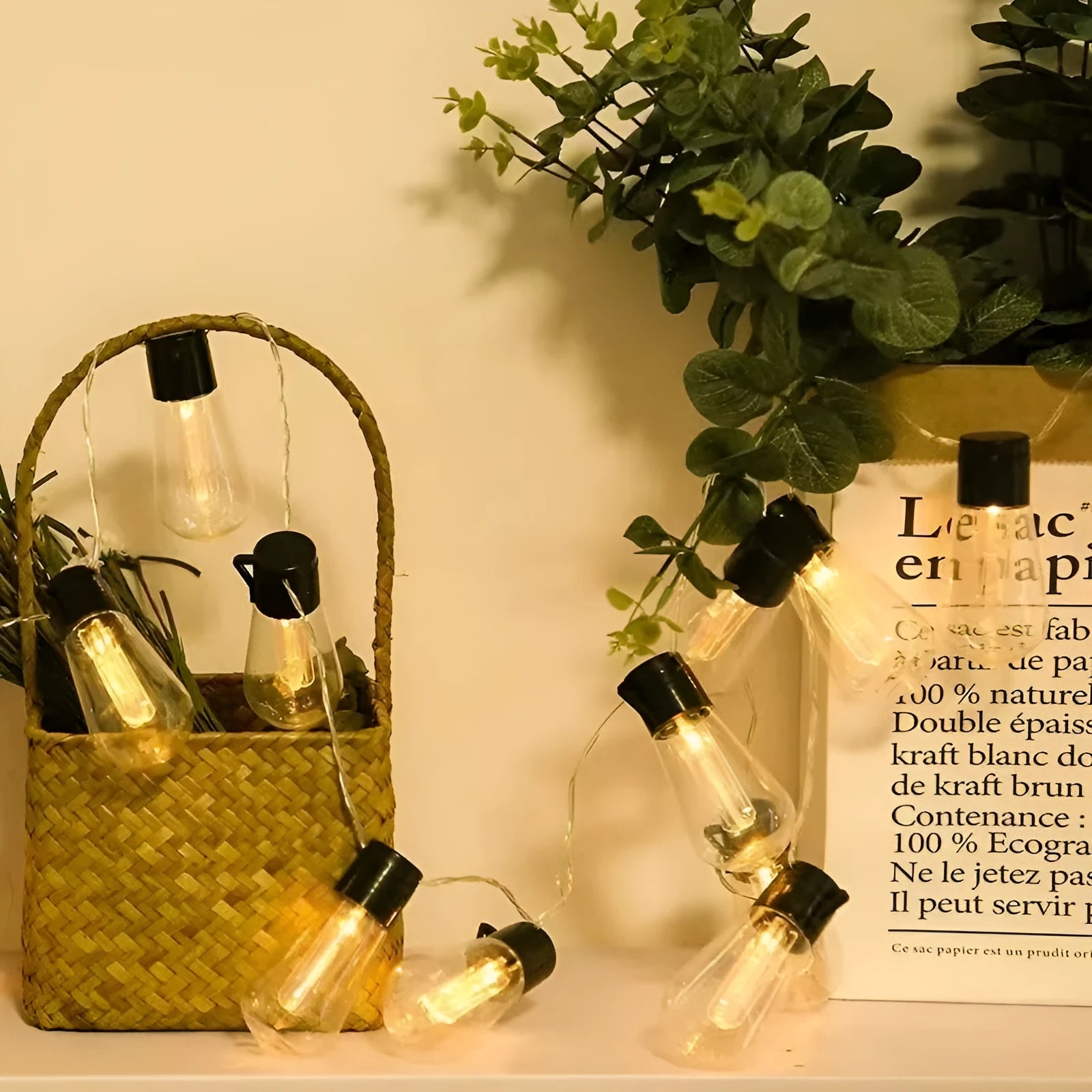 Retro glass infusion bottle-shaped outdoor string lights draped in a garden setting.