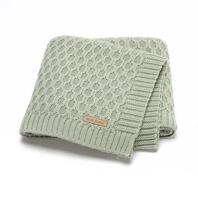 Solid colour infant hug blanket with textured lines, shown in acrylic fabric measuring 70 by 90 cm.