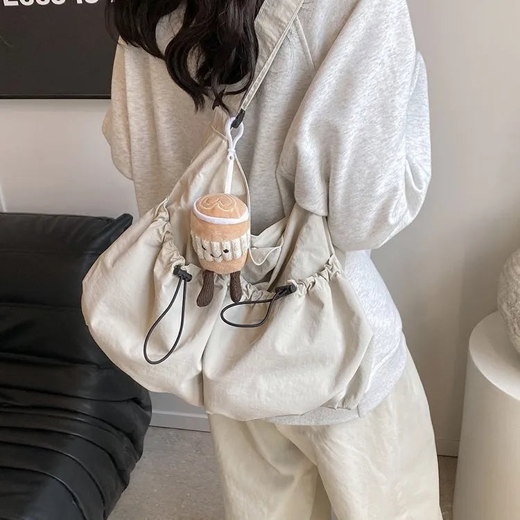 Soft green pleated foldable crossbody bag showing split pocket and internal mobile phone compartment