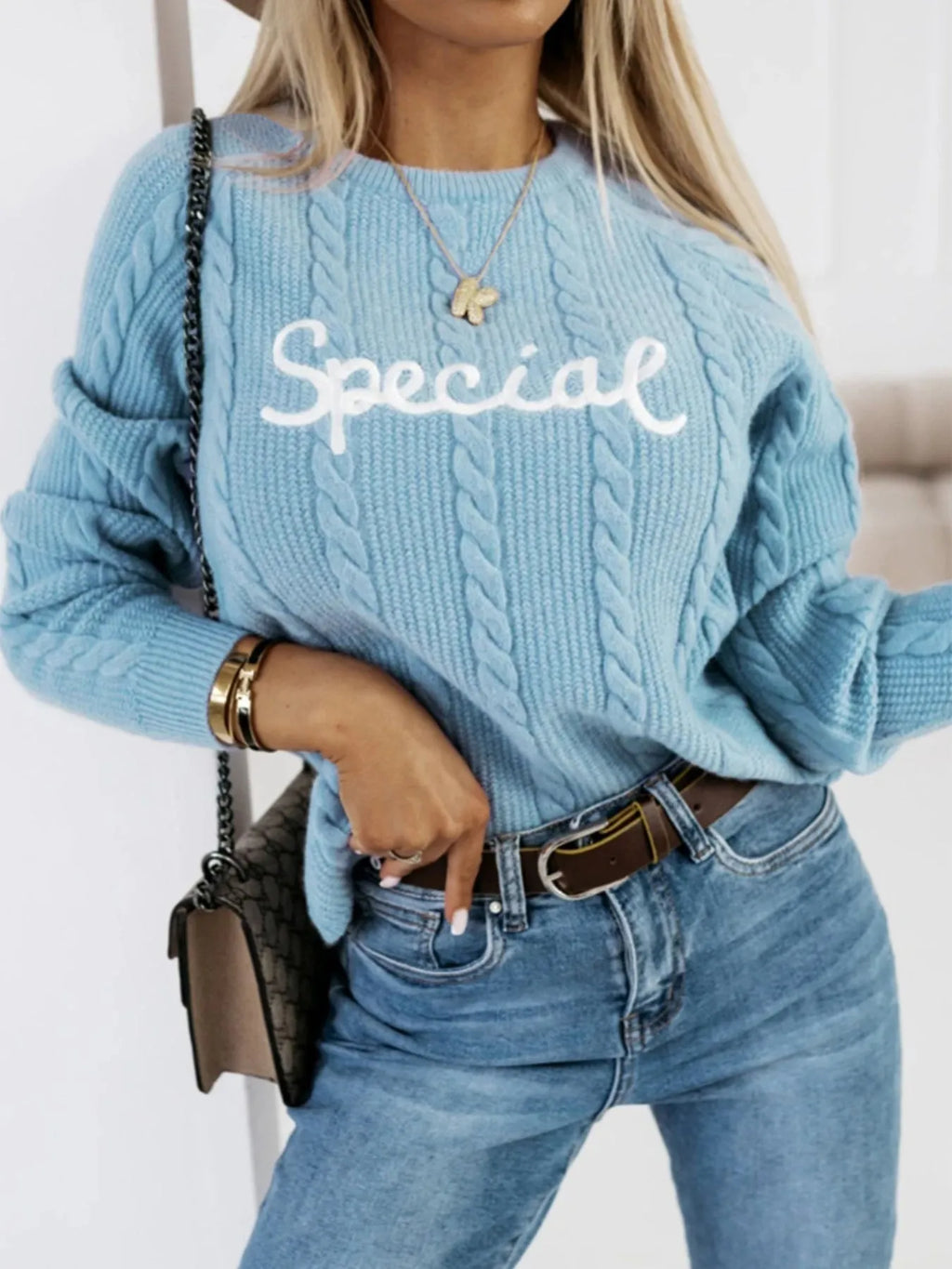 Blue crew neck pullover sweater with embroidered letters and numbers on the front.