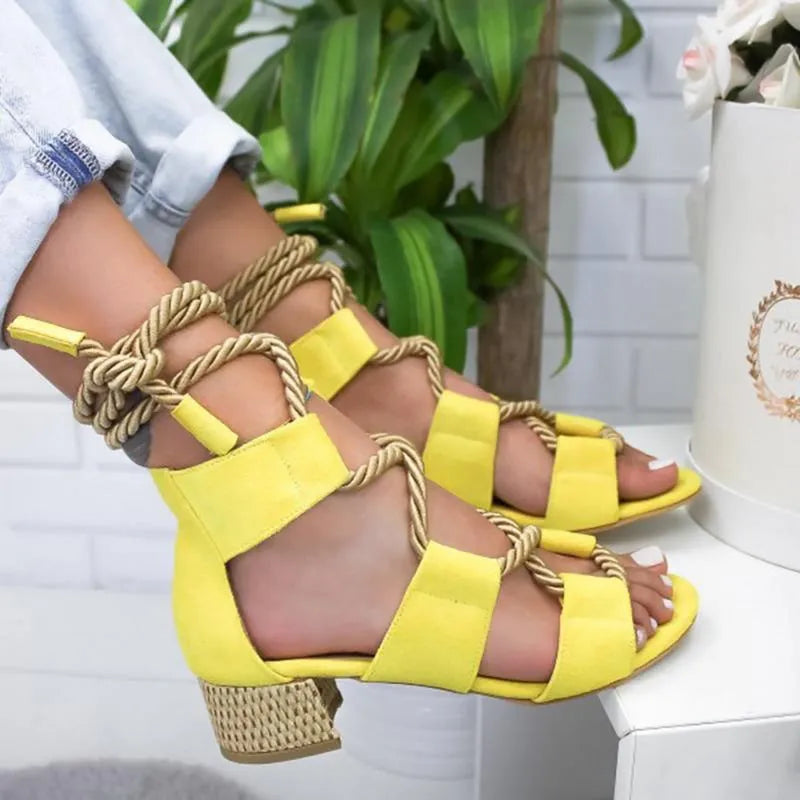 Women's beige suede sandals with thick mid-heel, front strap, and ankle strap on a plain background.