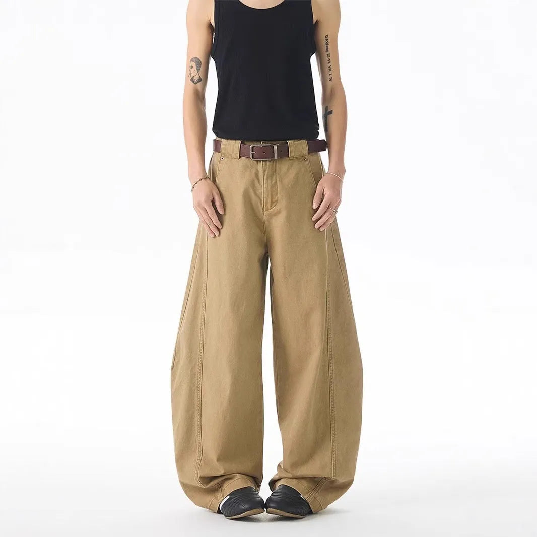 Brown men's loose-fit denim jeans with a straight leg and button fly on a neutral background.