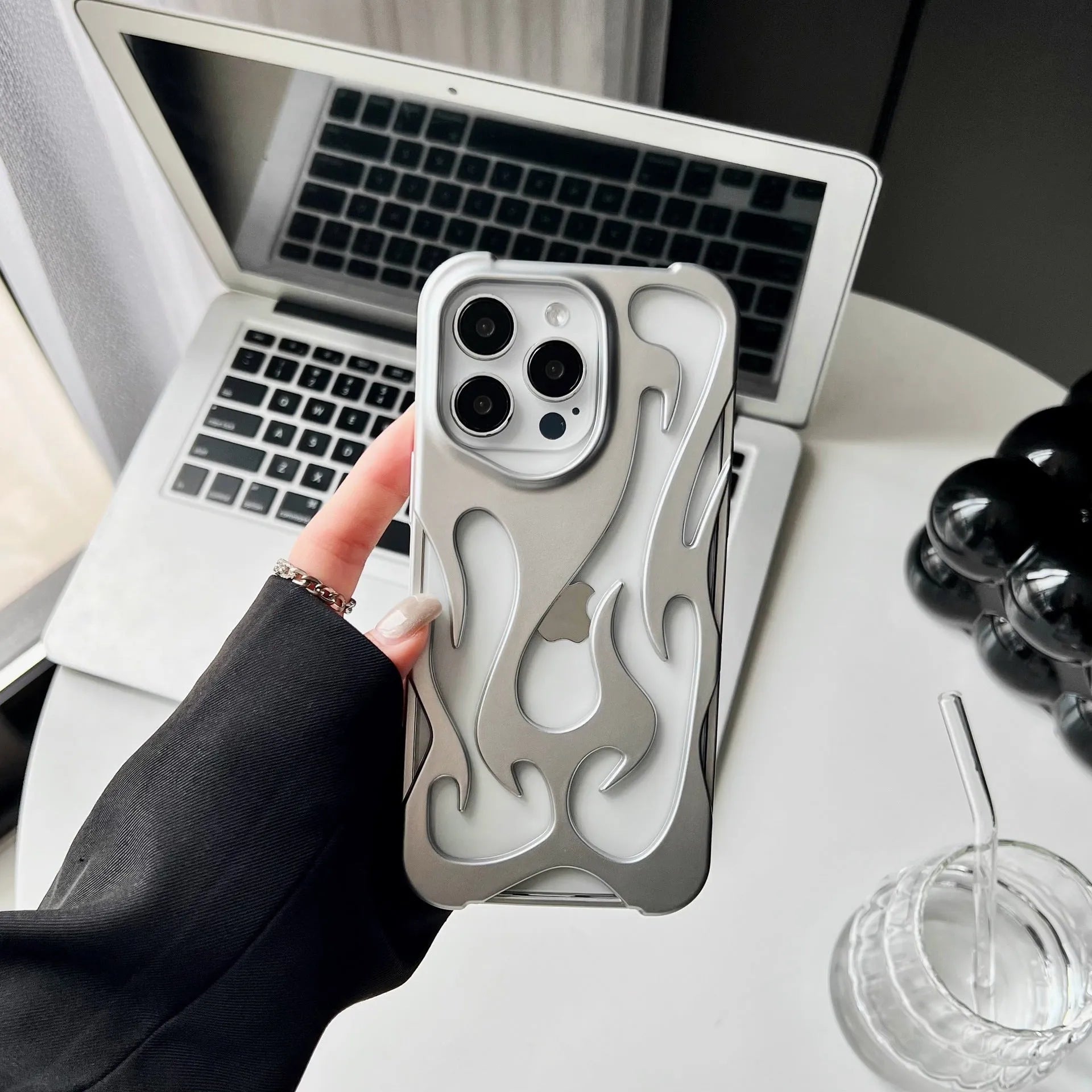 Electroplated hollow flame pattern TPU iPhone case in silver plating shown on a phone.