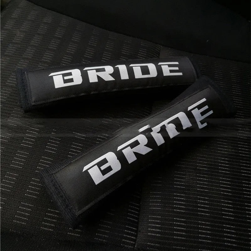 Pair of black car seat belt shoulder pads with embroidery, showing dimensions.
