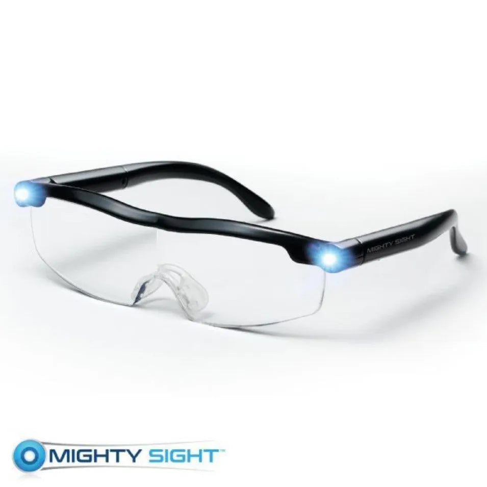 Transparent black USB LED reading light glasses with illuminated frames on a table.