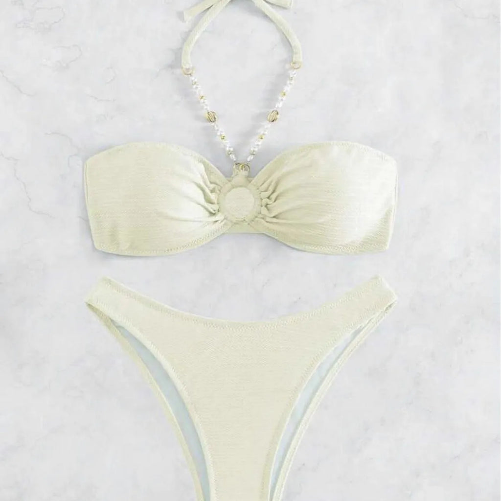 Women's creamy-white halter top and briefs bikini set for swimming on a beach