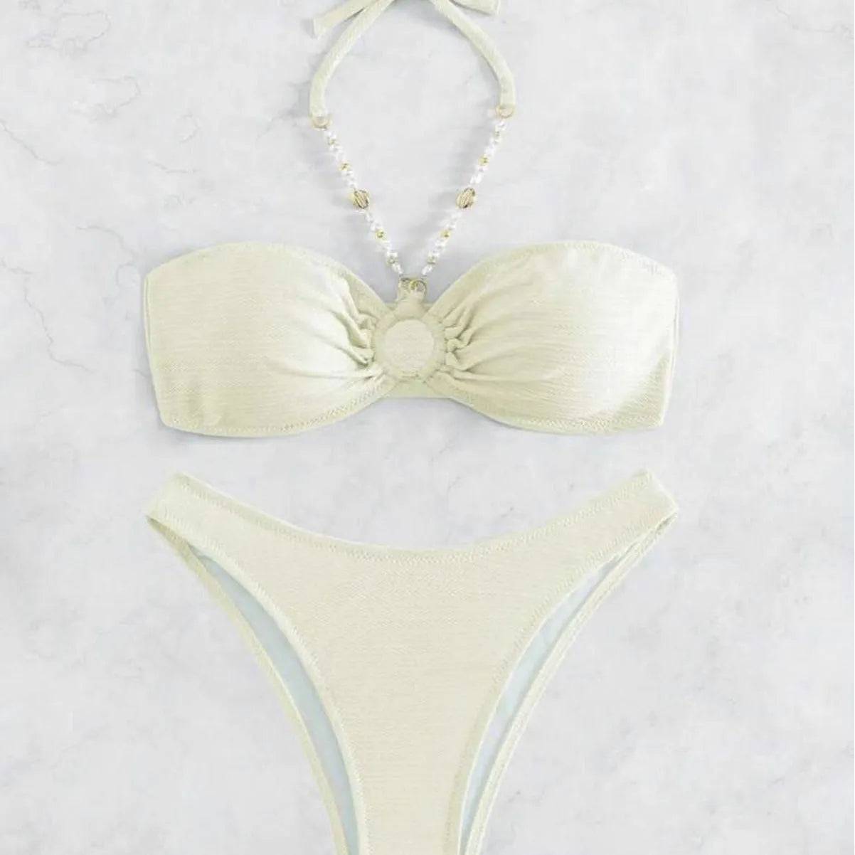 Women's creamy-white halter top and briefs bikini set for swimming on a beach