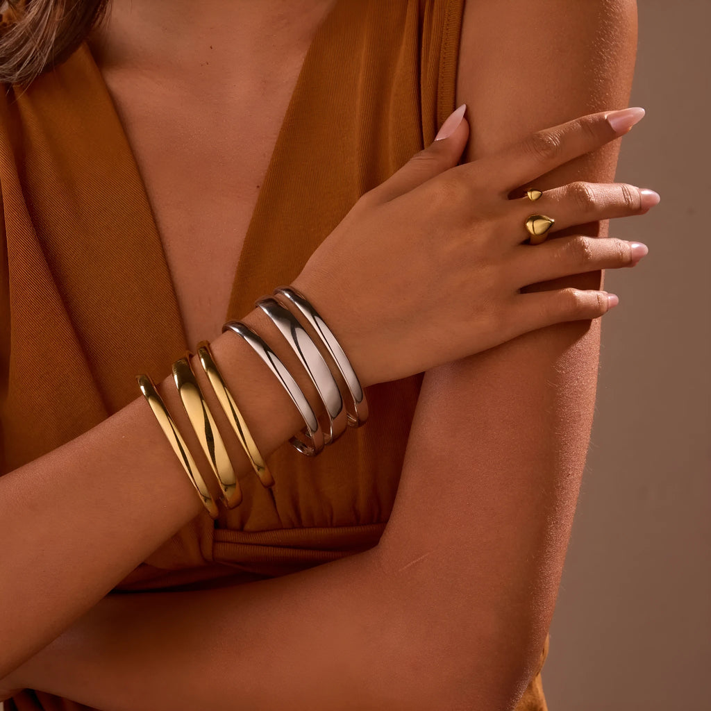 Geometric line design stainless steel women's bracelet with a simple opening clasp, shown in gold and steel colour options.