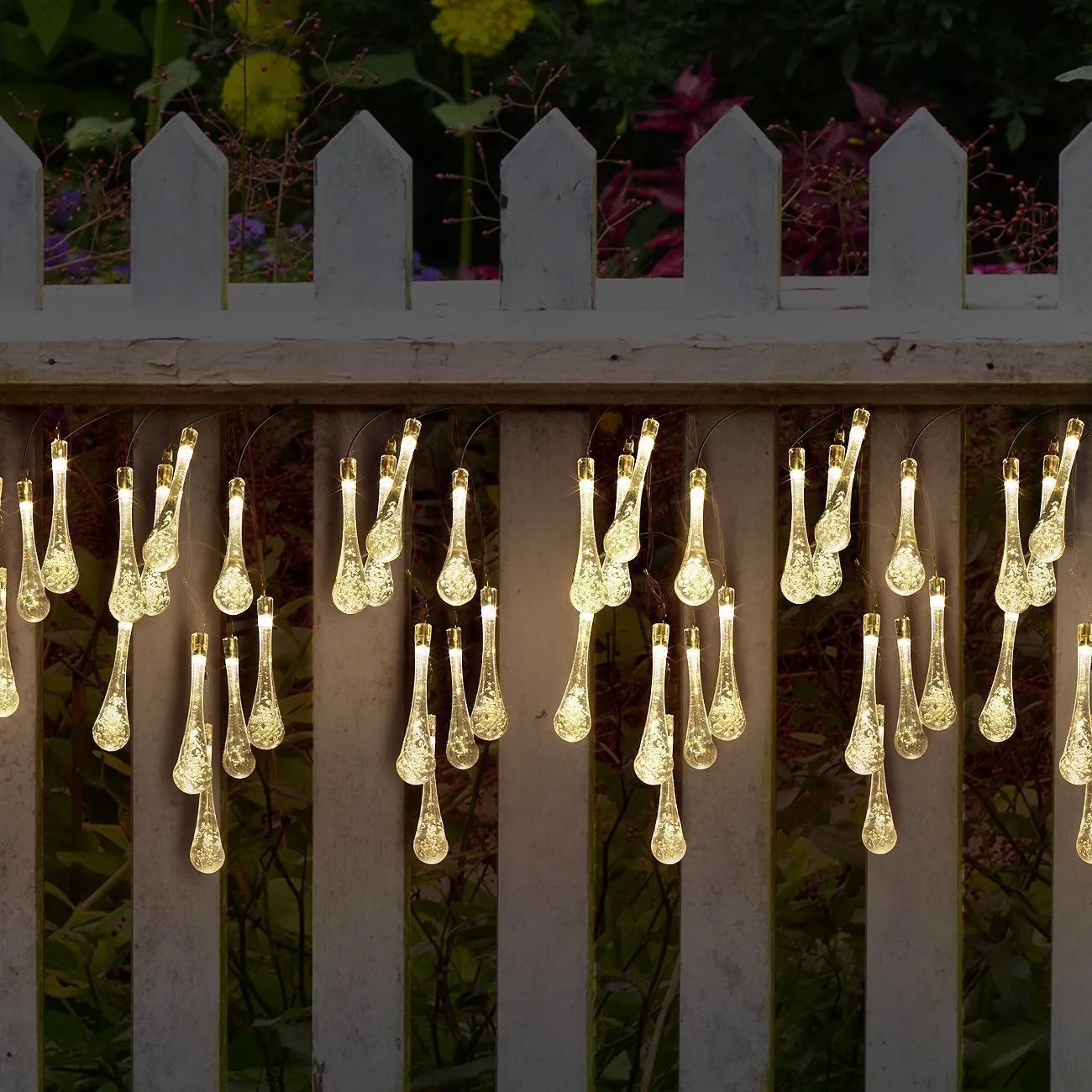 Solar-powered outdoor water drop LED string lights with warm white illumination on 6.5 metre waterproof cord