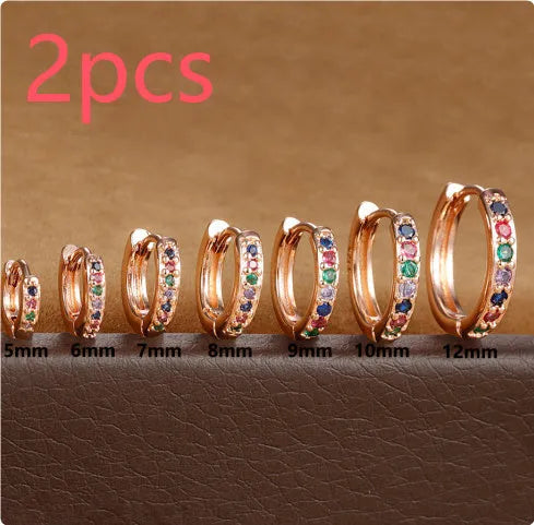 Circle zircon perforated stud earrings in gold, rose gold, and silver colour on a white background.