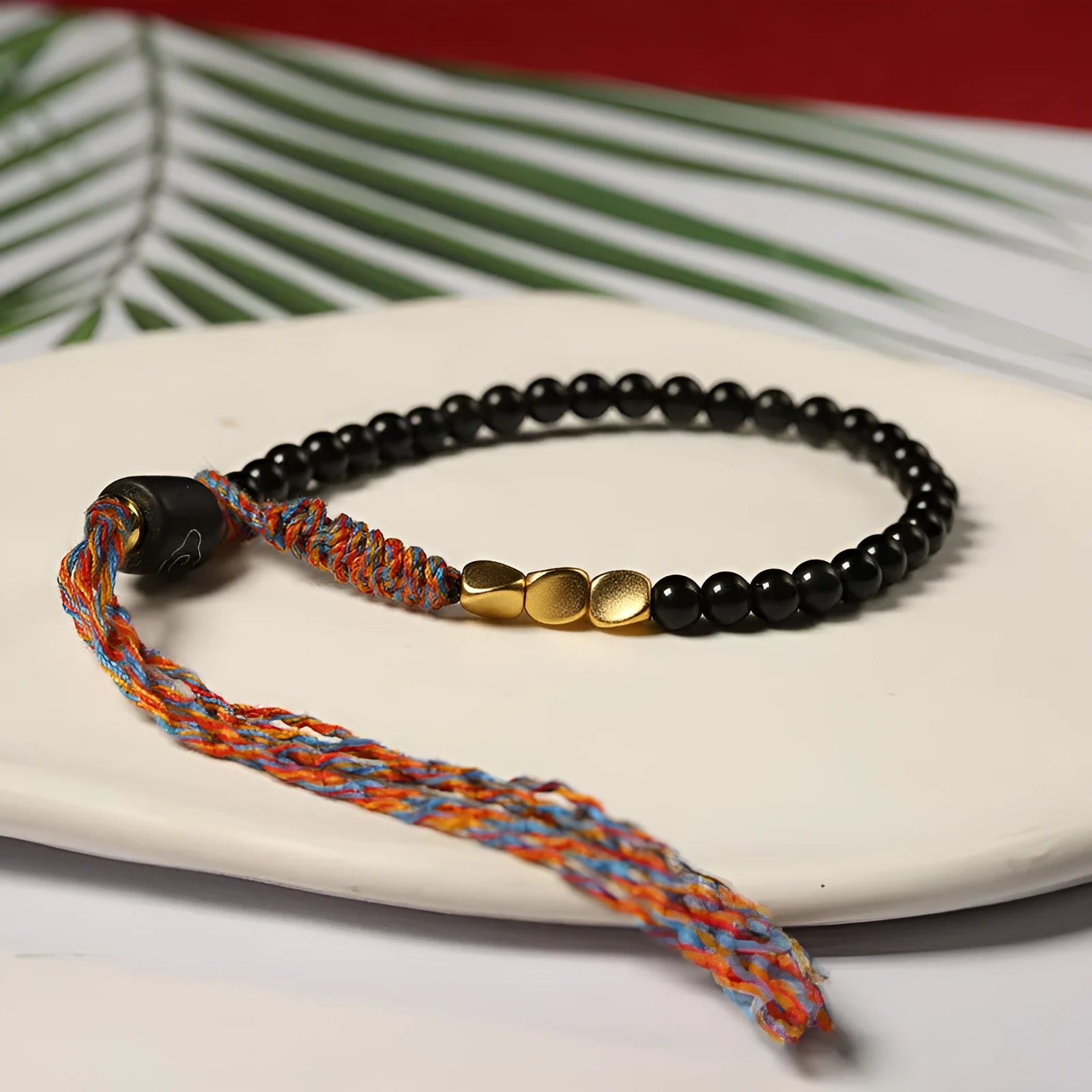 Hand-woven obsidian carrying strap bracelet showing woven texture and 4mm width