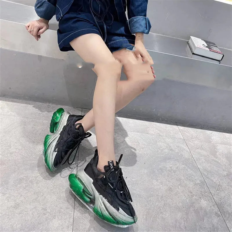 Women's green leather sports shoes with a thick clear jelly sole and white cross-tie laces.