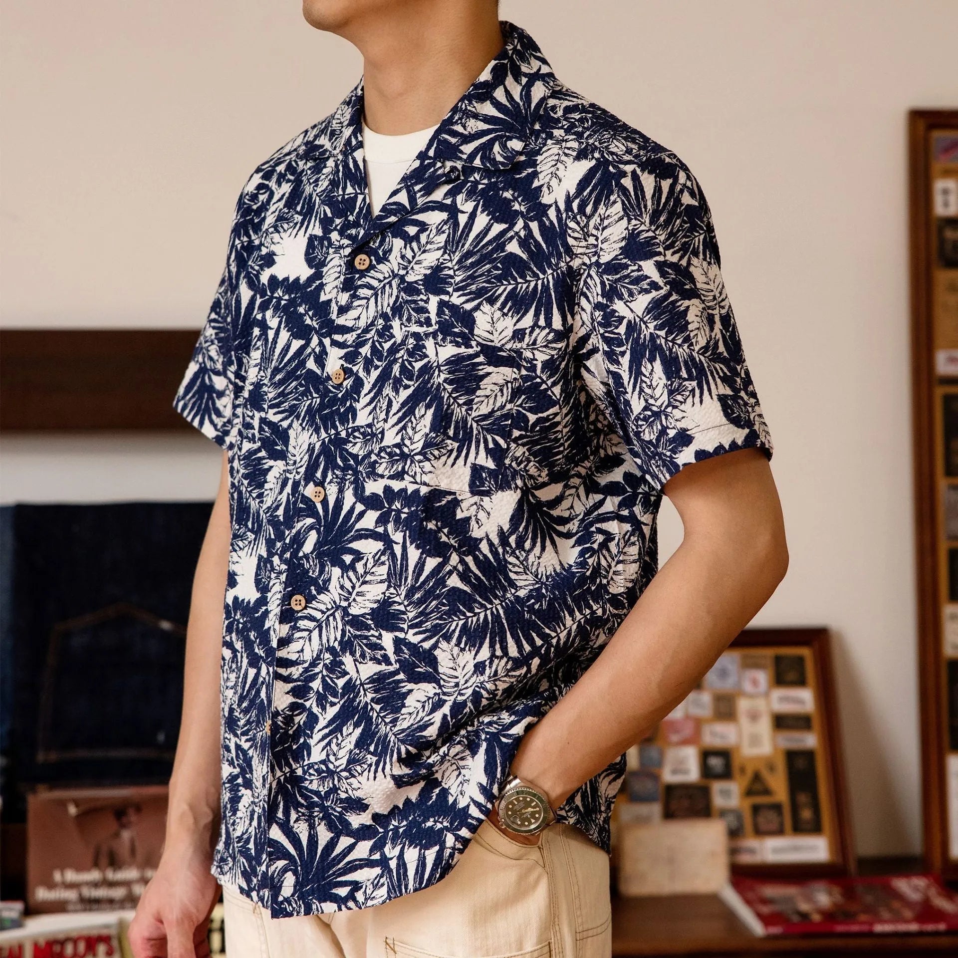 Man wearing a vintage floral print seersucker shirt with a Cuban collar in a green colour, showing loose fit.