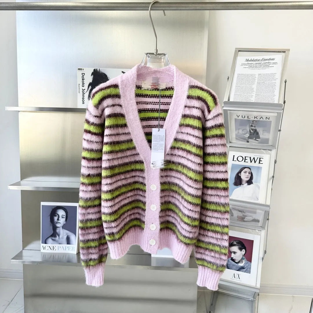 Pink women's wool knitted cardigan and round-neck pullover sweater with contrast details on a hanger.