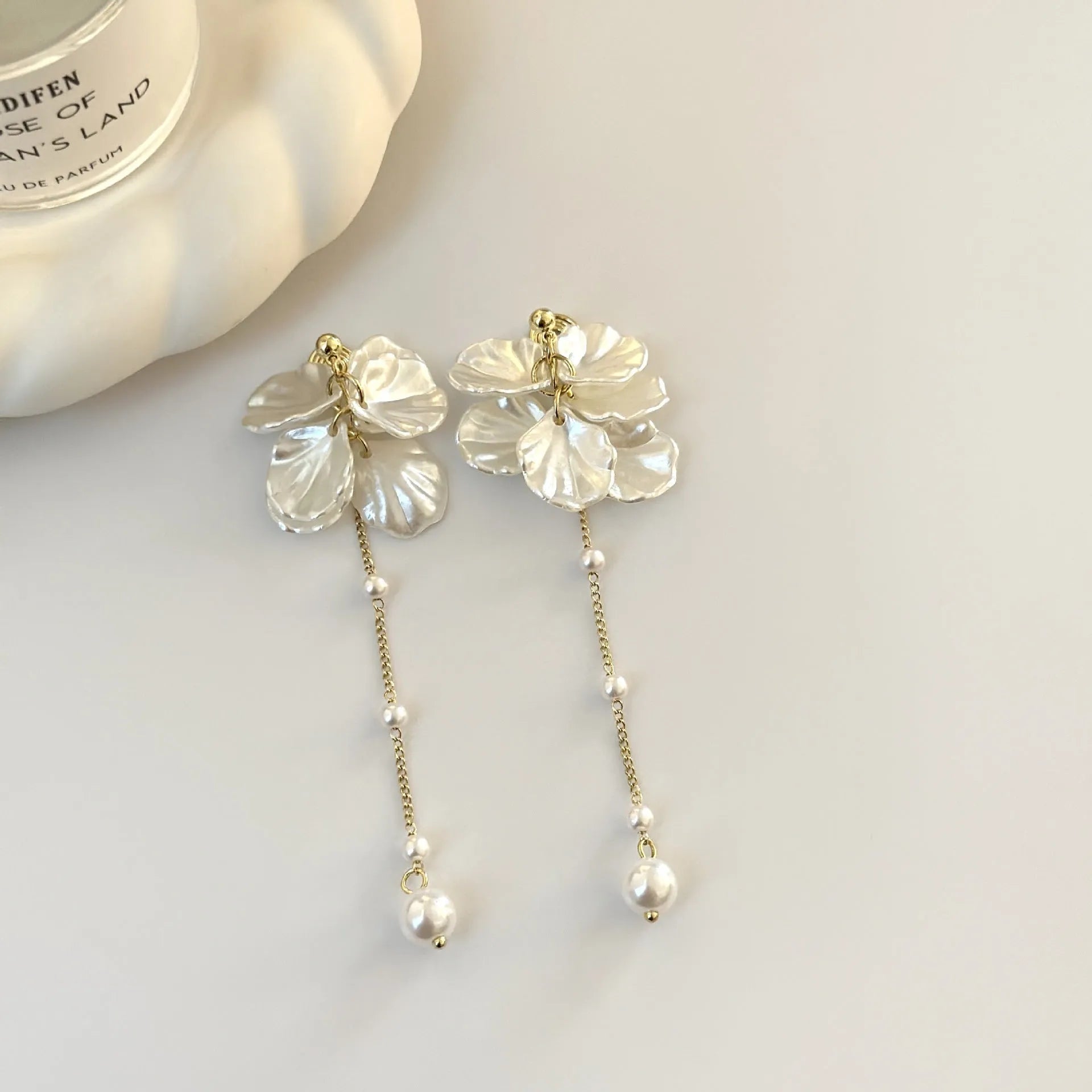Long shell pearl tassel earrings with acrylic construction and multiple ear clip options