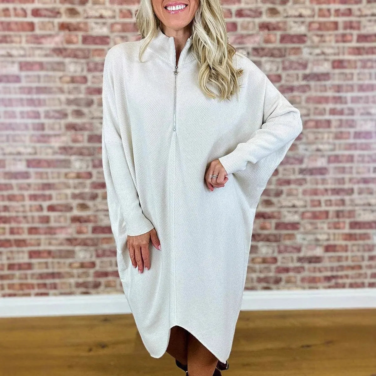 Women's solid colour loose fit knitted dress with raglan sleeves on a model.