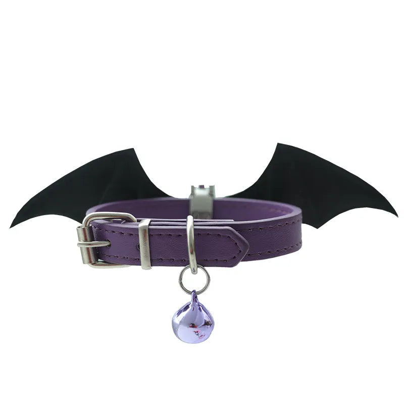Small black patent leather dog collar with decorative devil wings design on a white background.
