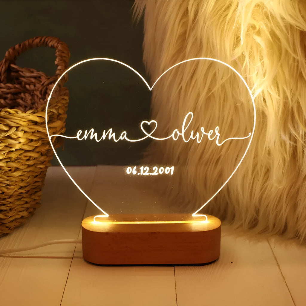 Custom transparent acrylic night light with engraved names and date, lit by LED base.
