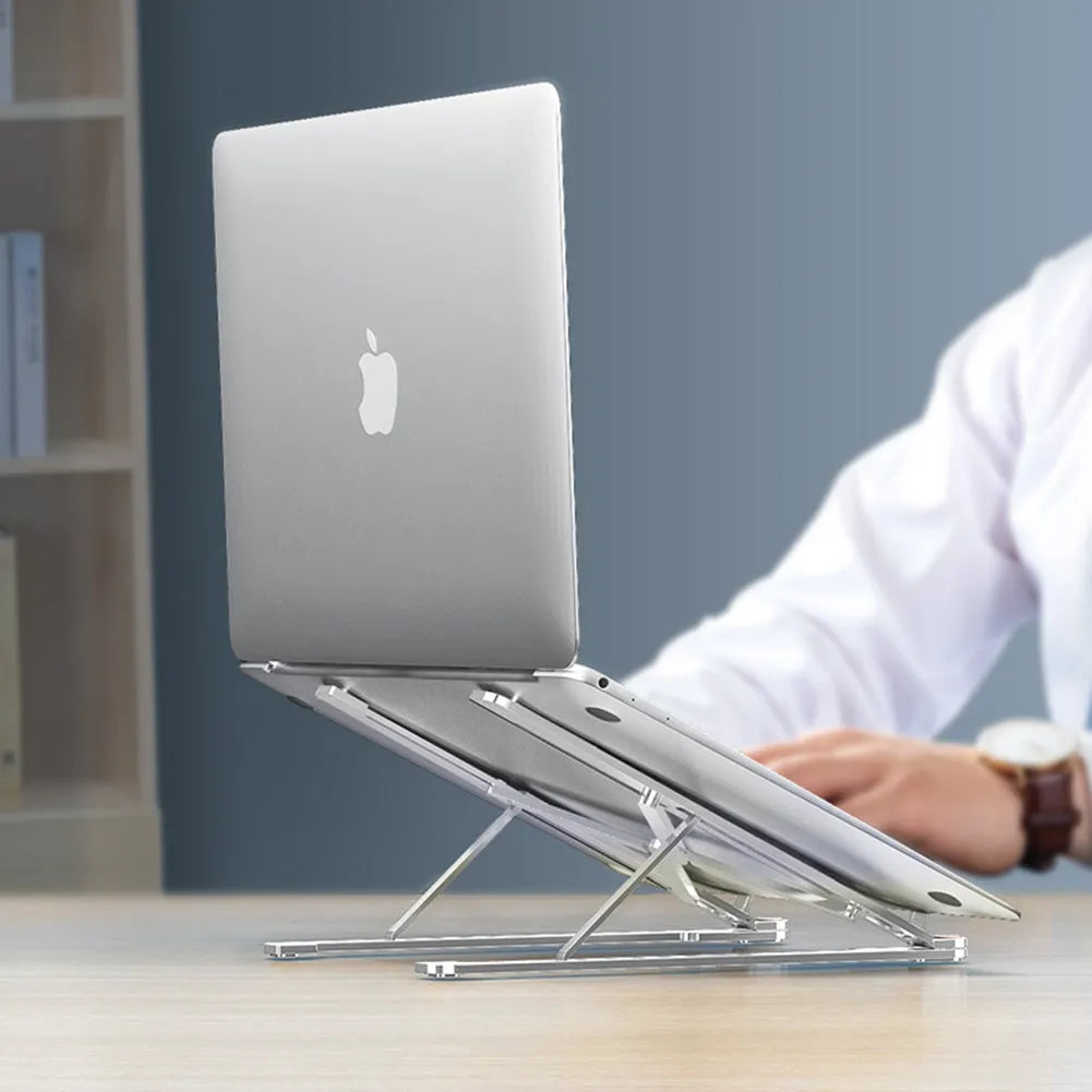 Aluminium laptop stand in silver colour, folded flat next to an open laptop for size comparison.