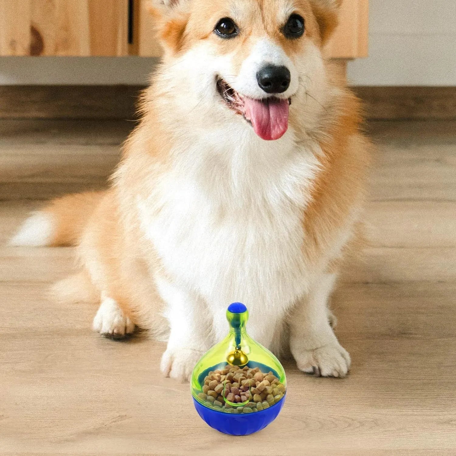 Blue and white durable pet treat dispenser tumbler toy for dogs and cats on a wooden floor.