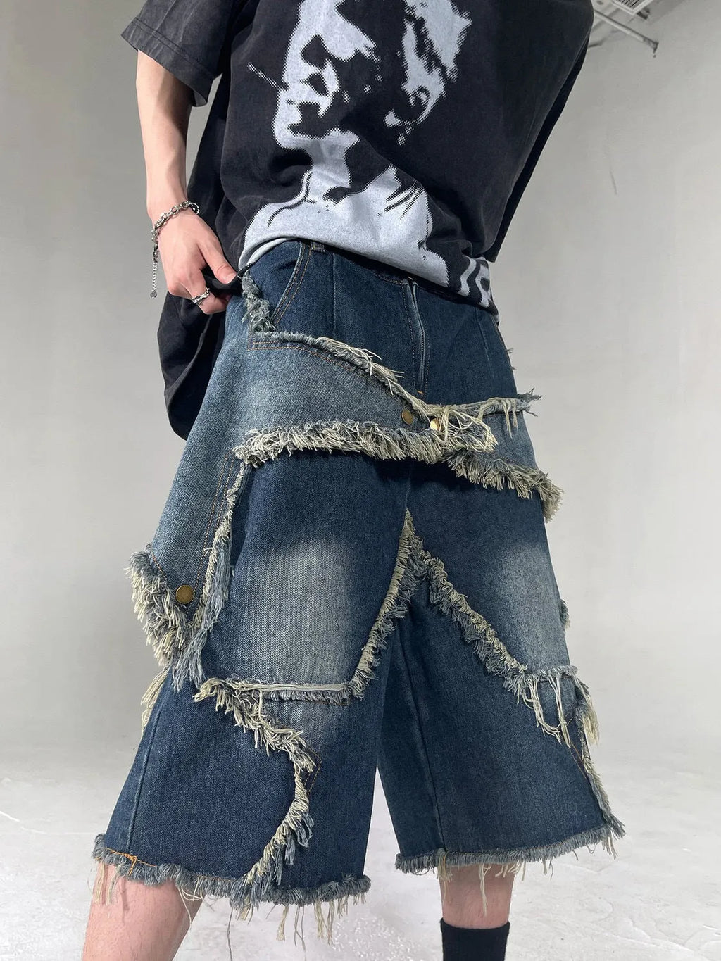 Blue men's denim shorts with a frayed hem and a large five-pointed star design on the leg.
