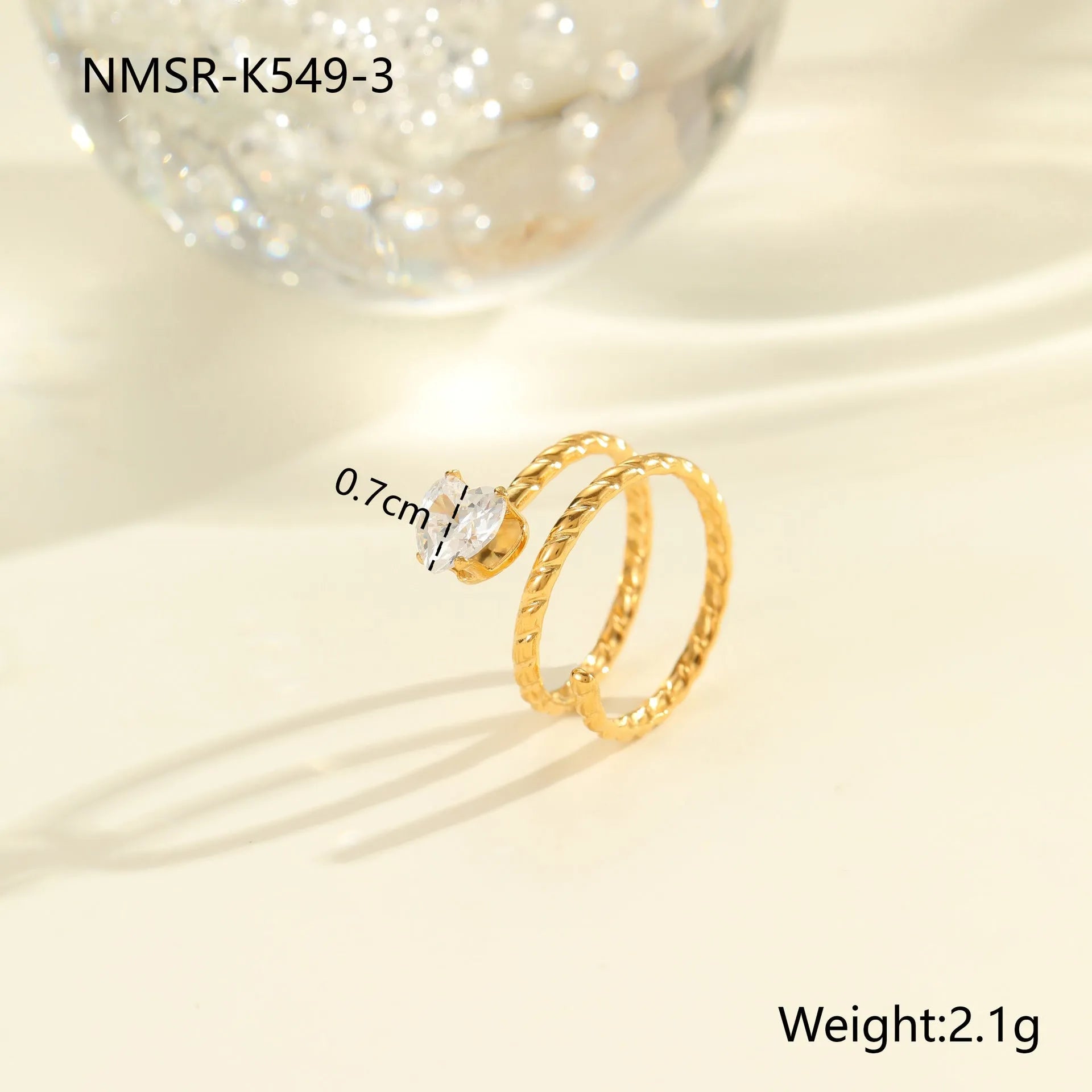 Gold inlaid zircon geometric heart and drop shape stainless steel ring on white background.