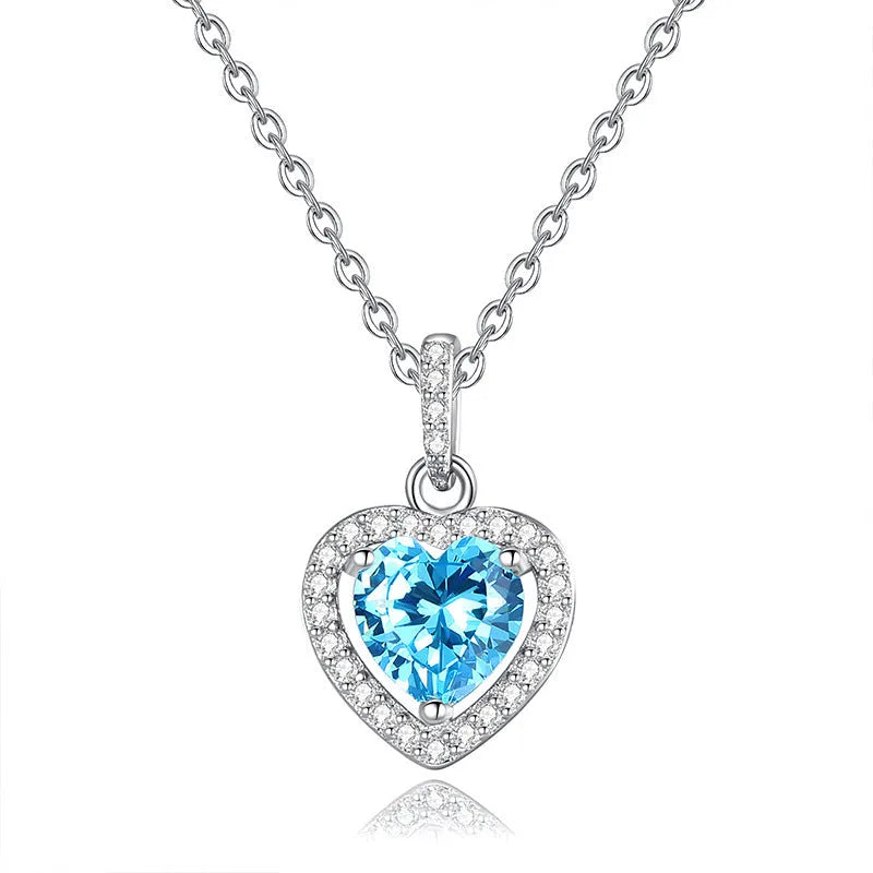 Close-up of a sterling silver heart necklace with an inlaid amethyst gemstone on a cross chain.