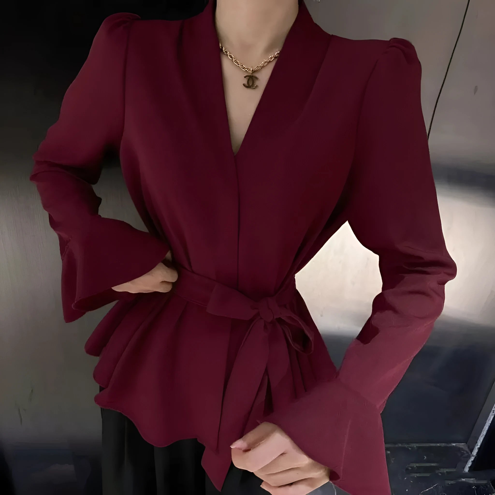Women's black French-style tied shirt with an irregular collar and long bell sleeves.