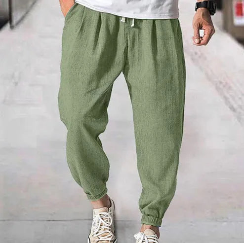 Men's loose casual cotton trousers with an elasticated ankle band in light green.